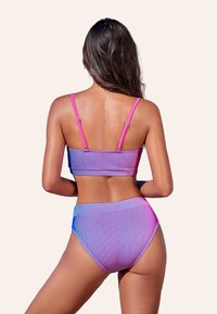 Bikini a righe viola e rosa con top a bandeau e parte inferiore a vita alta. Tessuto liscio, spalline regolabili e dettagli con motivo sfumato.