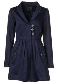 Laivastonsininen trenssitakki, jossa on lovikaulus, viisi napillista edessä, kaksi sivutaskua ja vyötärölle kerättyä yksityiskohtaa.