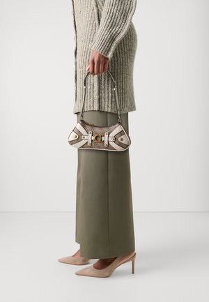 Lille håndtaske i beige og brun, med et tekstureret stof, guldfarvet hardware og dekorative hvide stropper. Stilet med en overdimensioneret sweater og brede bukser.