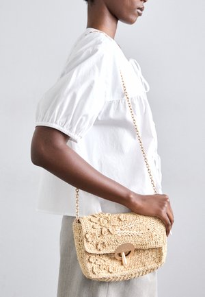Geantă din paie țesută, de culoare naturală, cu motive florale, închidere aurie și curea din lanț. Formă compactă, rectangulară, cu finisaj texturat.