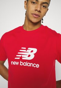 New Balance ESSENTIALS LOGO UNISEX - Nyomott mintás póló - team red