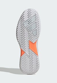 Kengän pohjassa on kumimateriaali, jossa on kalanruotokuvio, pääasiassa valkoinen ja oranssilla geometrisella korostuksella.