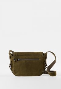 Olivgrüne Umhängetasche aus weichem Wildleder, mit einer vorderen Reißverschlusstasche, verstellbarem Schultergurt und minimalistischem Design.