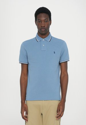 Polo shirt in light blue cotton with short sleeves, contrasting navy and white striped collar, and small logo on the left chest.