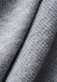 Hallhalli halli kangas pehmea tekstuuriga, ribakujunduse ja kerge sära ning hubase langevuse varjunditega.