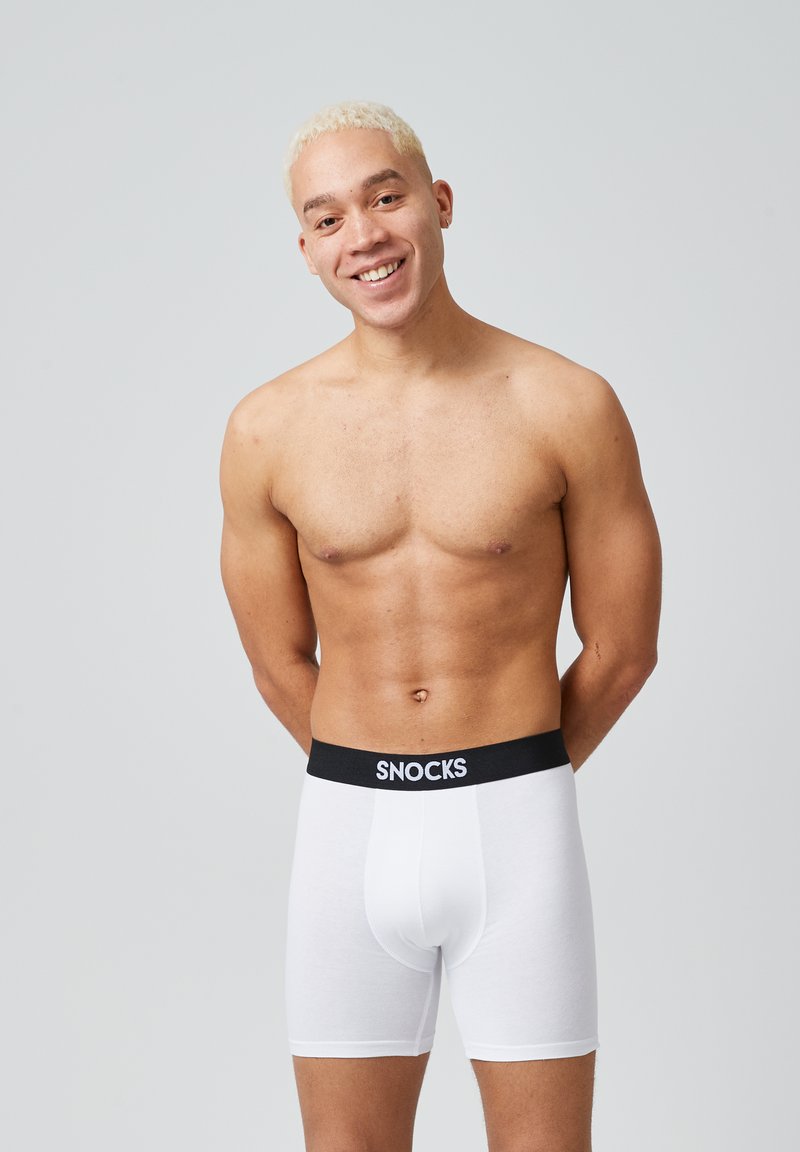Boxer da uomo bianchi in cotone con una fascia elastica nera che riporta il logo "SNOCKS", con una texture liscia e una forma aderente.