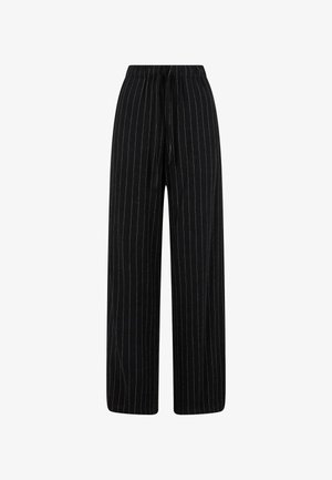 Czarne spodnie o szerokich nogawkach z elastycznym paskiem, z pionowymi białymi prążkami, wykonane z miękkiego materiału. Prosty fason bez dodatkowych zdobień.