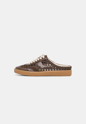 Ruskea punottu nahkainen slip-on-tennari valkoisilla nauhoilla ja vaaleanruskealla kumipohjalla, esitetty sivuprofiilista yksinkertaisella vaalealla taustalla.