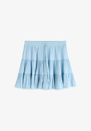 Gaiši zilas vairāklīmeņu mini svārki ar savilktu audumu, elastīgu jostasvietu un priekšpuses saišu detaļu uz balta fona.