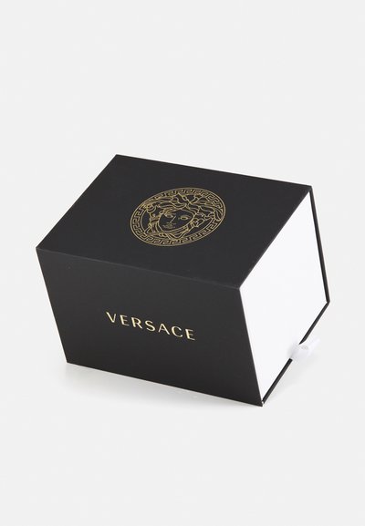 Juodas stačiakampis dėžutė iš kartono su auksiniu logotipu ir emblema viršuje. Viduje yra balta ir mažas traukimo darbo elementas.