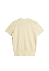 Keltainen lyhythihainen poolopaita, jossa on resorikaulus. Siinä on hienovarainen geometrinen kuvio ja resorireunus. Materiaali vaikuttaa pehmeältä ja neulotulta.