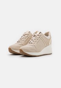Beige Wildlederschuhe mit Perforationen, cremefarbenen Akzenten und einem eleganten Keilsohle. Mit Schnürdesign und goldenen Hardware-Details.