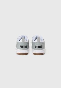 Grå atletik sko med hvide accenter, der har en gummisål og fremtrædende sort "PUMA" branding på bagsiden. Glat overflade med polstret krave.