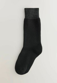 Calcetín negro con un puño texturado en gris oscuro, hecho de una tela suave. Diseño simple con puntera redondeada y talón reforzado.