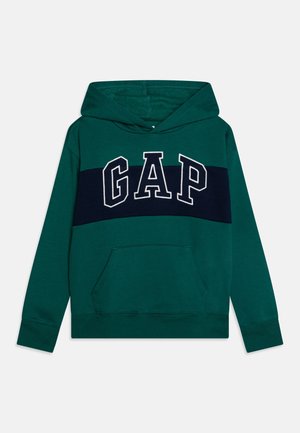 Sweat à capuche vert foncé avec une bande horizontale bleu marine sur la poitrine et de grandes lettres "GAP" blanches en contour sur le devant.