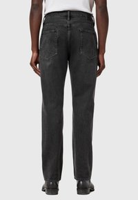 Sorte denimjeans med lige pasform, der har to baglommer og en let falmet tekstur. Taljeringen har en standard løkke.