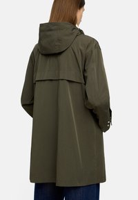 Oliwkowa, lekka kurtka z kapturem, z tylnym krojem, opadającymi ramionami i zapinanymi mankietami. Gładka tekstura, casualowy design.