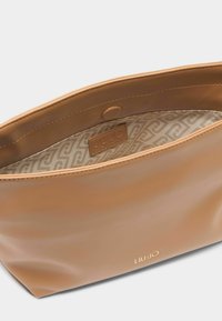 Tansynthetisch handtas met een gladde textuur, ritsluiting en interieur met een gestreepte voering. Gouden "LIU JO" logo aan de buitenkant.