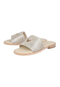 Sandali in pelle metallizzata argentata con un design a cuore tagliato nella parte anteriore. Presentano una suola in legno piatta e una fodera interna liscia.