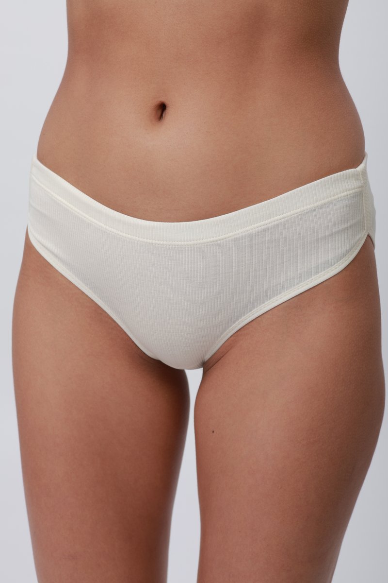 Culotte de bikini couleur crème, côtelée, avec une taille large et plate, texture lisse, design ajusté, sans matériel visible ni motifs.