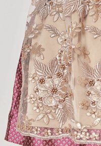 Tissu beige transparent avec une broderie florale dorée complexe et des accents de perles sur un matériau violet à motifs.
