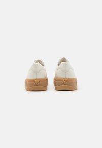 Hvit lær sneakers med gummirubber såler, rund form, og subtile søm detaljer. Logo preget på hælen. Minimalistisk design.