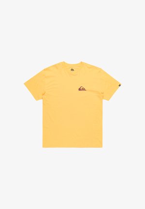 Gelbes Baumwoll-T-Shirt mit kurzen Ärmeln und Rundhals. Verfügt über ein kleines braunes Logo auf der linken Brust und ein Etikett am Ärmel.