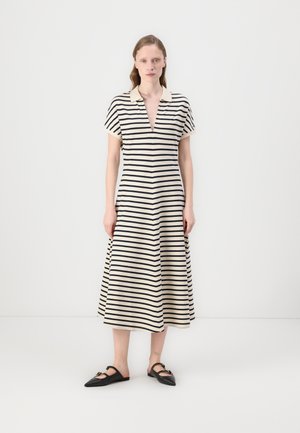Stripet midikjole i krem og marineblå, med krage, korte ermer, V-hals og flagrende skjortekant. Brukt med svarte slip-on sko.