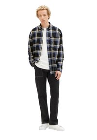 Schwarze und blaue karierte Flanellhemd über einem weißen T-Shirt, kombiniert mit schwarzen Jeans und weißen Sneakers. Lässiger Schnitt mit einer Brusttasche.