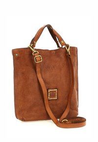 Borsa tote in pelle marrone con due manici superiori e una tracolla removibile. Presenta una superficie texture e un emblema decorativo con borchie.