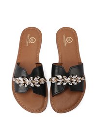 Sandali neri in cuoio con design a fiocco testurizzato e una fila di gemme finte lungo la cinghia. Suole color beige con dettagli di cucitura.