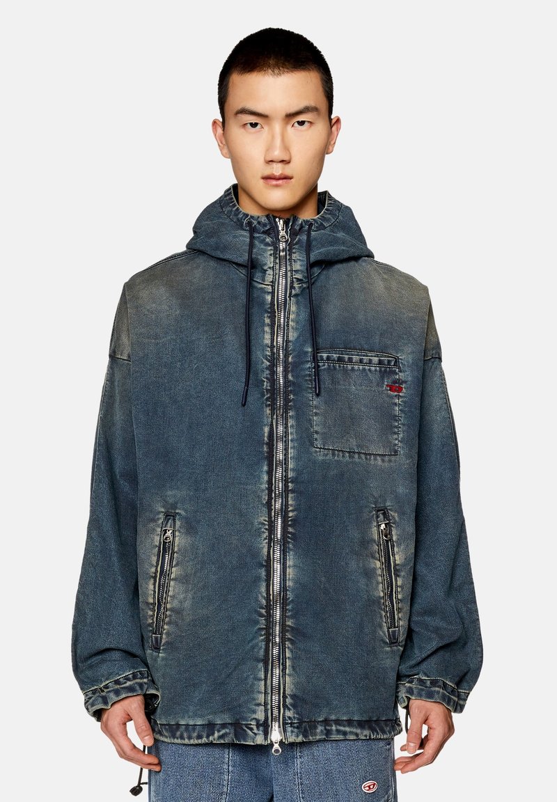 Jeansjacke in verblausstem Blau mit Kapuze, frontaler Reißverschluss und seitlichen Taschen. Verfügt über kontrastierende Nähte und eine Brusttasche.