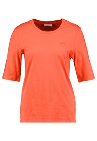 Krátký rukáv oranžového trička z bavlny, s kulatým výstřihem a vyšitým logem Lacoste na hrudi v ladící niti.