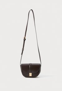 Borsa a tracolla in pelle marrone con forma curva, dotata di chiusura a pattina, accessori in oro e una lunga tracolla regolabile.