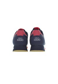 Sneaker blu navy con accenti rossi, suola in gomma e dettaglio "SINCE 1890" sul tallone. Progettato con una texture liscia e un profilo basso.