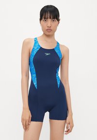 Navy blue swimwear with a fitted design, featuring blue and green tropical patterns on the shoulders and sides, made from stretchable fabric.