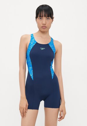 Marineblaue Badebekleidung mit taillierter Passform, die blaue und grüne tropische Muster auf den Schultern und Seiten zeigt, gefertigt aus dehnbarem Stoff.