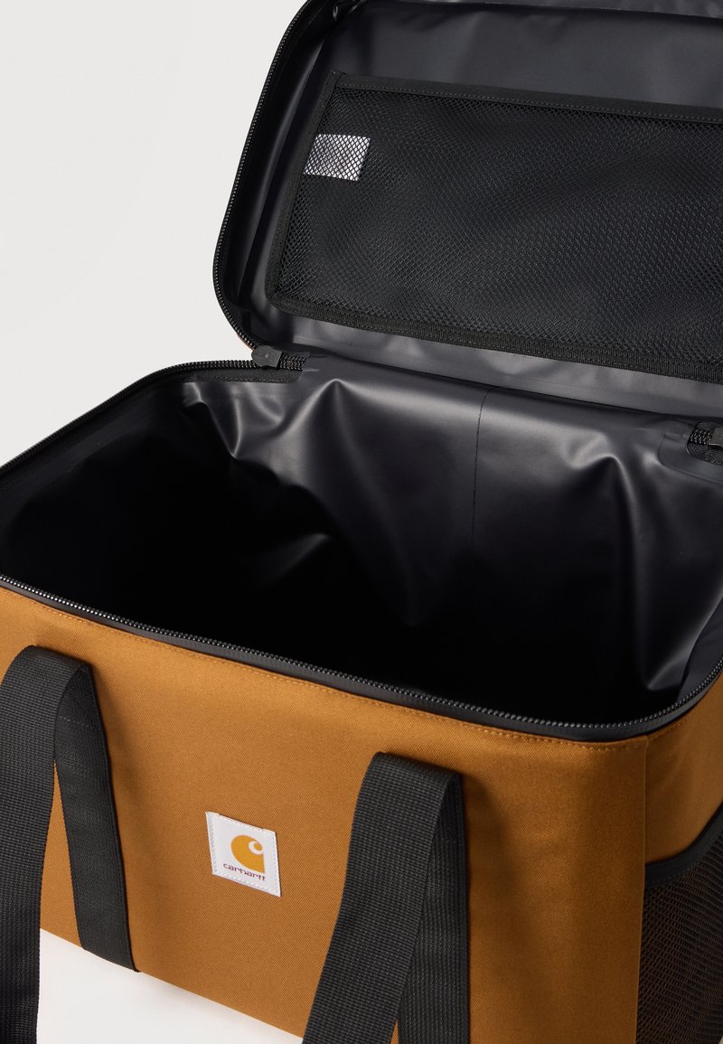 Bolsa enfriadora blanda de color marrón con asas negras, tapa abierta que muestra el interior impermeable negro y un bolsillo de malla dentro de la solapa superior.