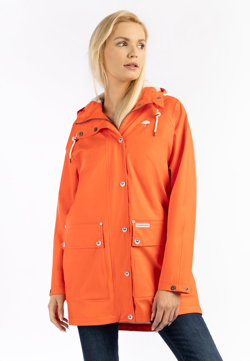 Vízálló narancssárga esőkabát kapucnival, patentgombokkal, két elülső zsebbel, állítható húzózsinórral és fehér logóval a mellkason.