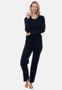 Marinblått set av loungekläder med långärmad topp och löst sittande byxor, tillverkat av mjukt tyg, med rund halsringning och justerbart midjeband.