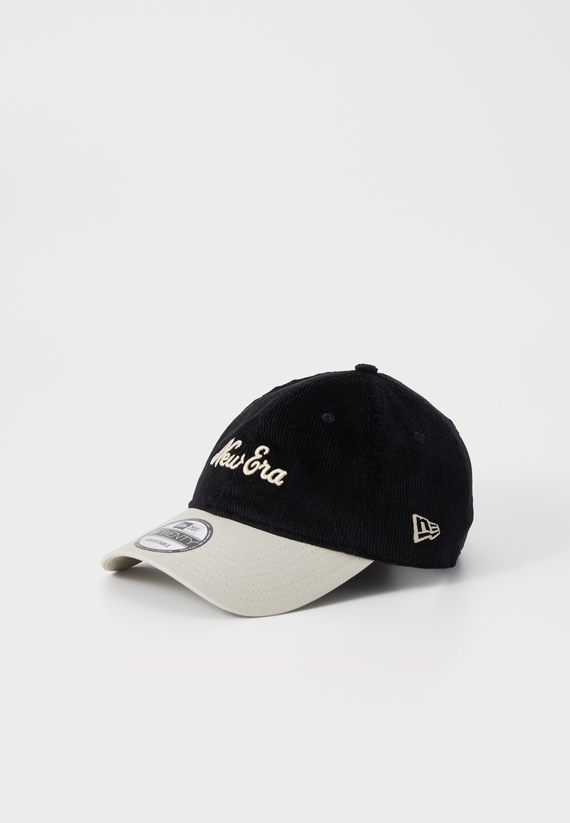 Casquette en velours côtelé noir avec une visière beige. Présente "New Era" en broderie crème et un petit logo sur le côté. Forme structurée, texture douce.