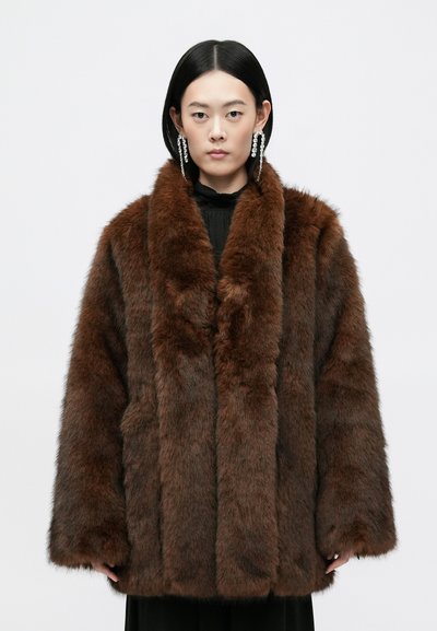 Manteau en fausse fourrure marron avec un large col, des manches longues et une surface douce et texturée. Présente une coupe ample et sans fermetures visibles.