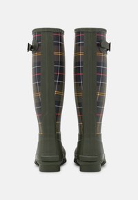 Bottes en caoutchouc étanches, vertes, jusqu'aux genoux, avec un motif écossais foncé, arborant des accents jaunes, rouges et blancs ; sangle à boucle sur le côté.