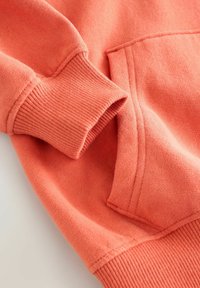 Korallefarbener Sweatshirt mit gerippten Bündchen und Saum, ausgestattet mit einer vorderen Kängurutasche und weichem, strukturiertem Stoff.