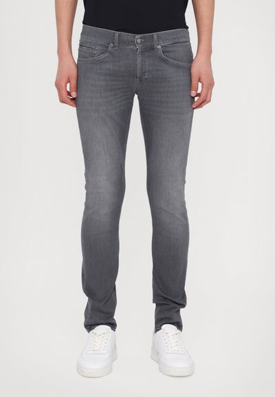 Jeans skinny gri din denim, cu un design clasic cu cinci buzunare, croială slim și modele de uzură subtile. Purtați cu adidași albi.