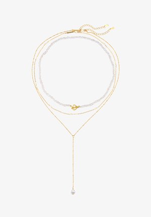 Collares en capas con cadenas doradas, perlas blancas y un colgante suspendido. La línea del cuello se realza con diseños delicados y texturas variadas.