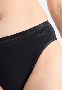 Zwarte katoenen slip met een gladde textuur, voorzien van een low-rise ontwerp en een subtiele logo op de tailleband.