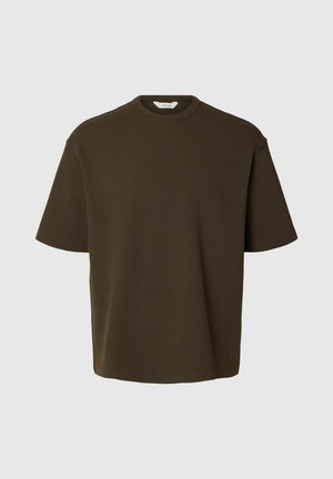 T-shirt à manches courtes en maille texturée vert olive foncé avec col rond et coupe ample sur fond gris clair.