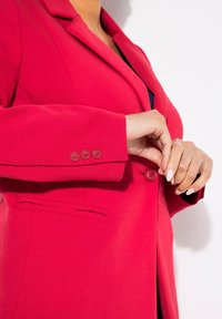 Rode blazer met een tailleurfit, met notch-revers en drie knopenaccenten op de mouwen. Heeft een zijzak en een gladde textuur.