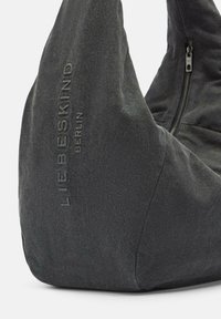 Torba hobo w ciemnoszarym materiale o teksturowanej powierzchni. Posiada widoczny zamek błyskawiczny oraz wytłoczone logo "LIEBESKIND BERLIN" po jednej stronie.